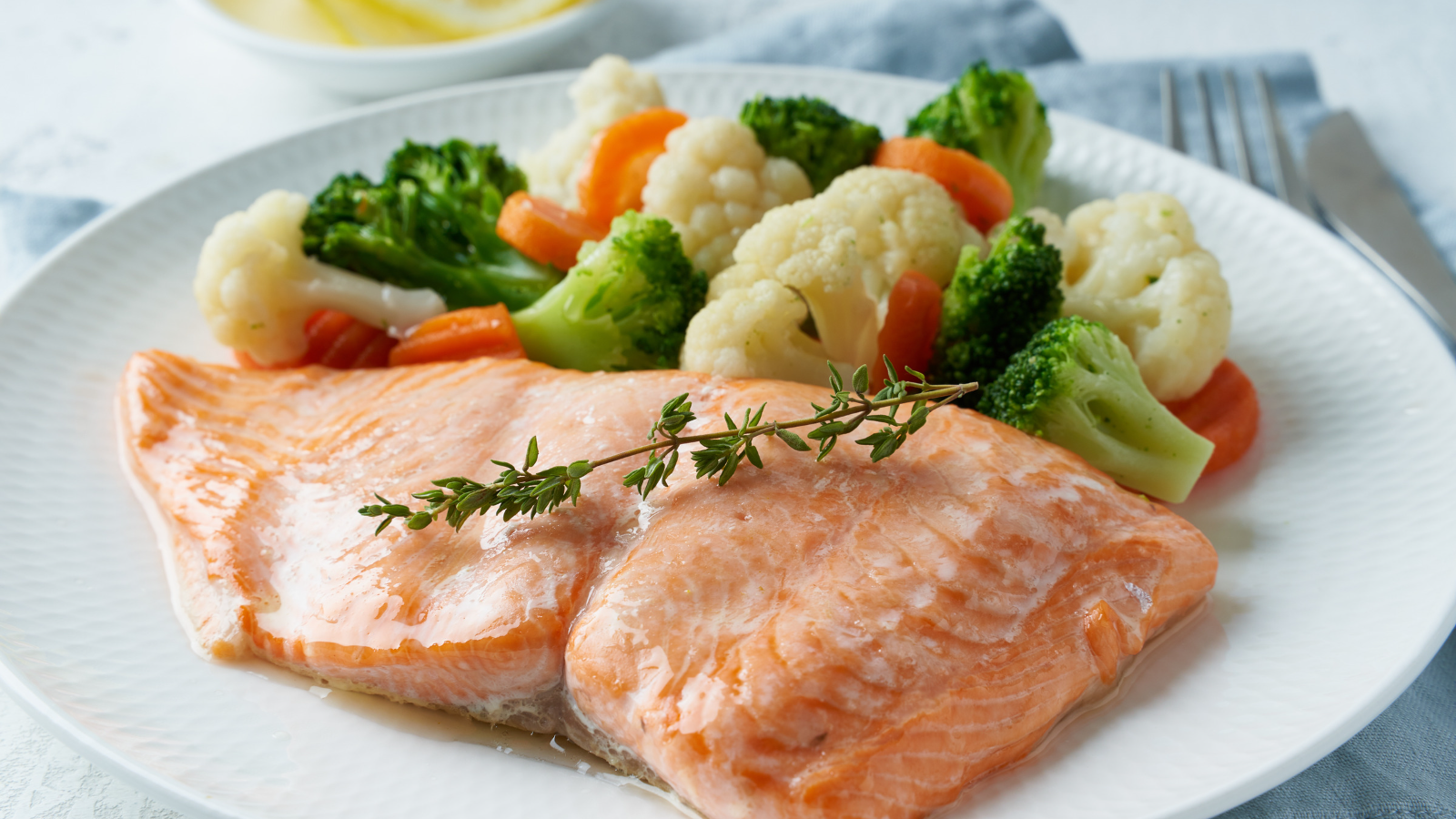 Steamed salmon and mixed vegetables on white plate